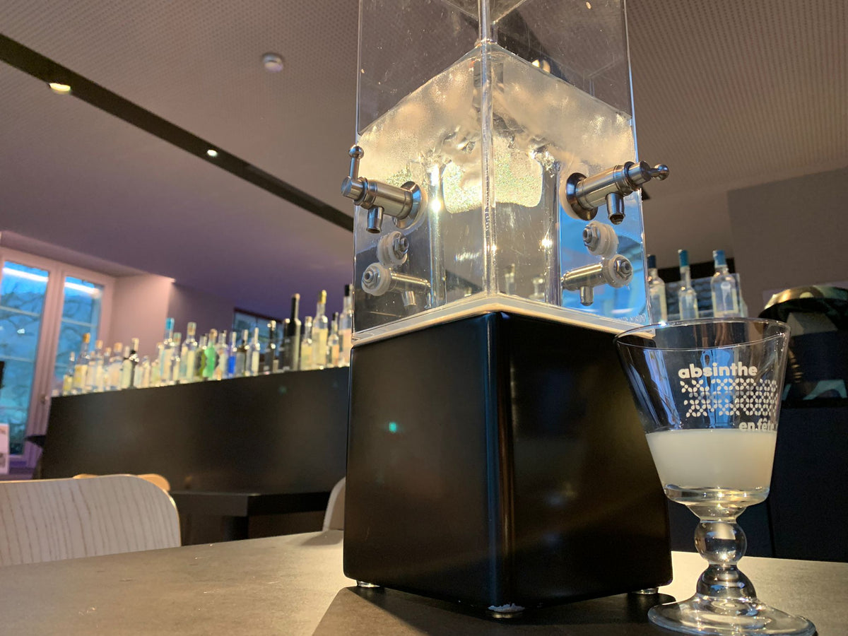 An absinthe fountain on the museum bar beside a filled Absinthe en Fete glass