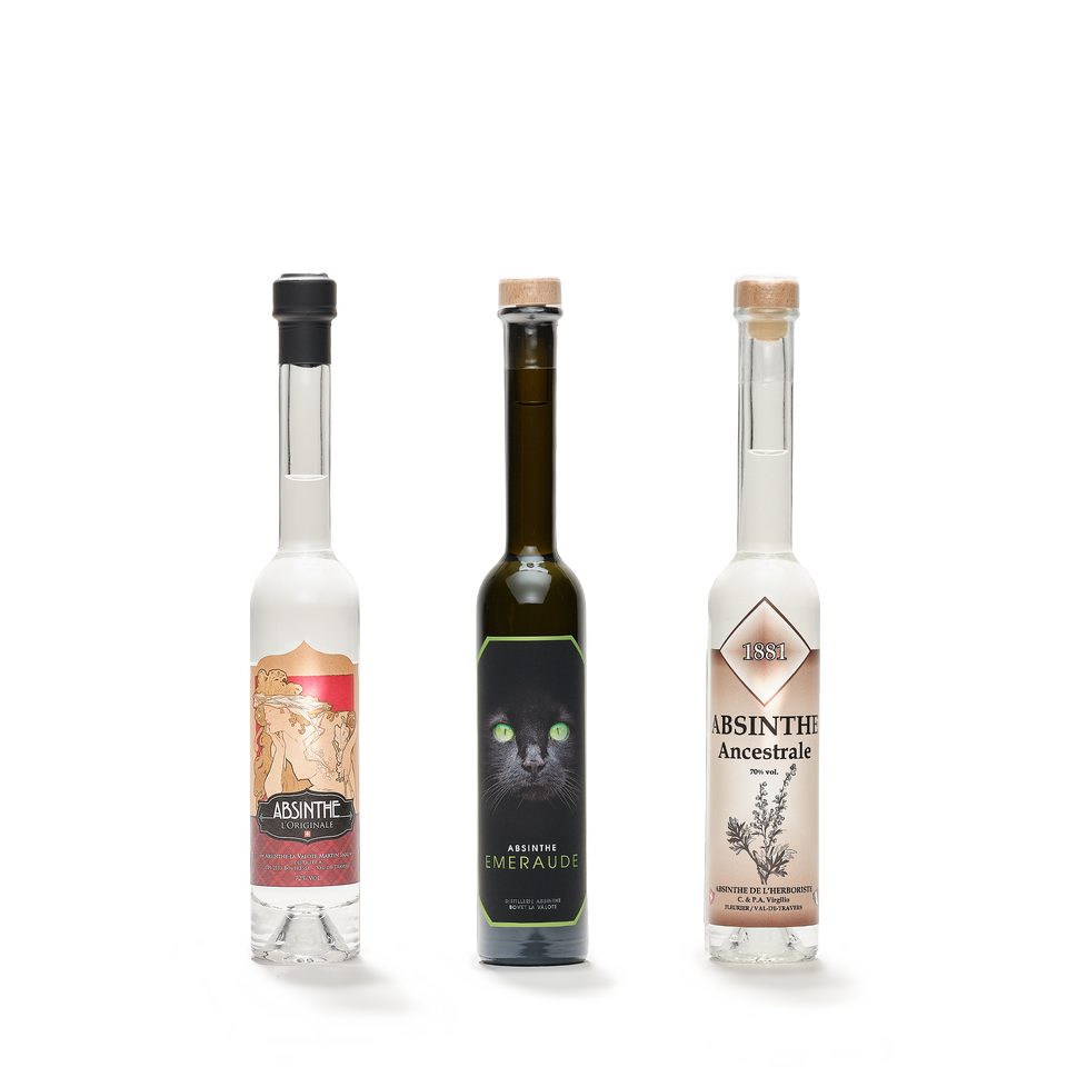 Three tall slim bottles side by side, two of clear spirit and one of dark green glass, each corked and differently labelled.