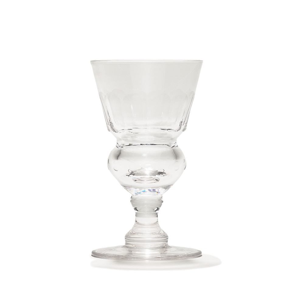 A clear absinthe glass with a faceted conical bowl above a bulbous reservoir, seen straight on.