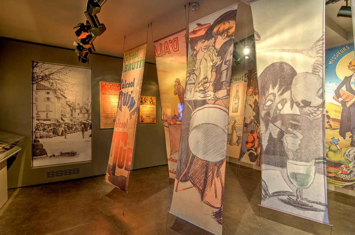 Absinthe diabolisation exhibition room with vintage prohibition-era posters and display cases