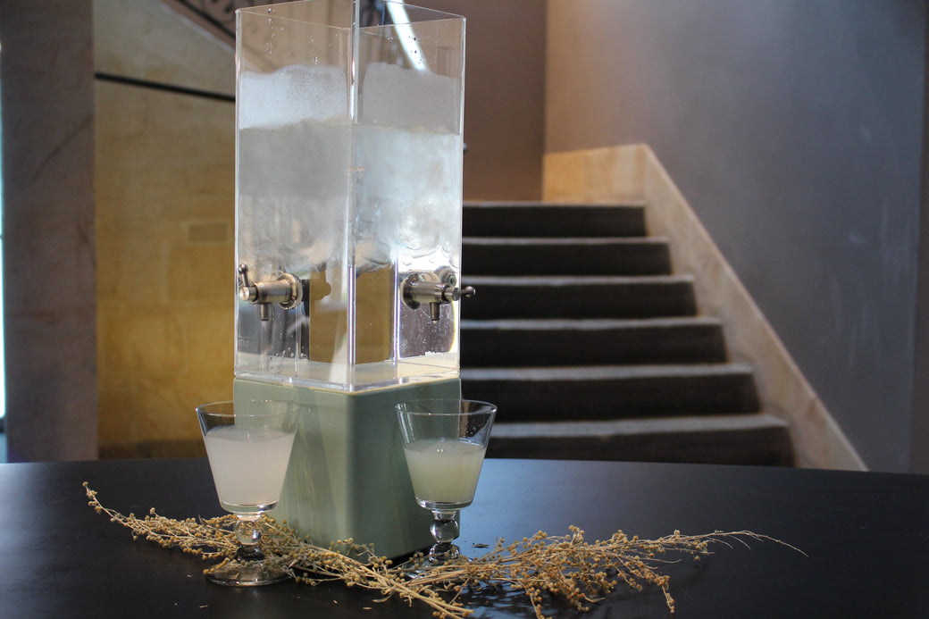 Two absinthe glasses beside a drip fountain at the Maison de l'Absinthe tasting bar