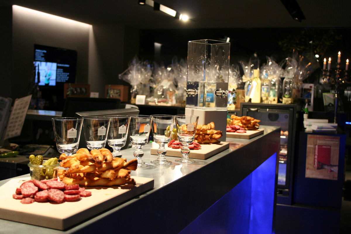 Absinthe glasses and a fountain beside a buffet on the museum bar